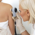 Dermatologist examining patient skin