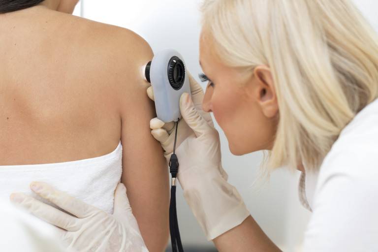 Dermatologist examining patient skin